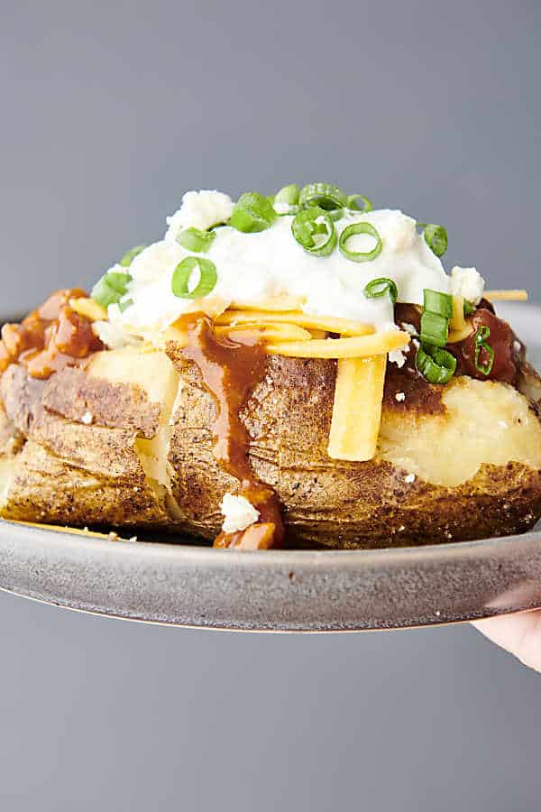 holding air fryer baked potato on a plate