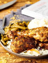 Air fryer fried chicken on a plate with green beans and potatoes
