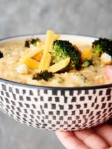 bowl of broccoli cheddar soup held