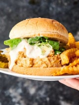 buffalo chicken sandwich on plate with fries held