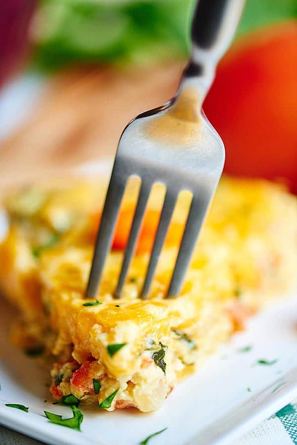 Slice of quiche being stabbed with fork
