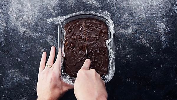 Chocolate fudge being cut with butter knife