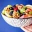 fruit salad with honey walnuts blue background