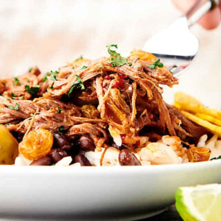 forkful of ropa vieja being lifted off plate