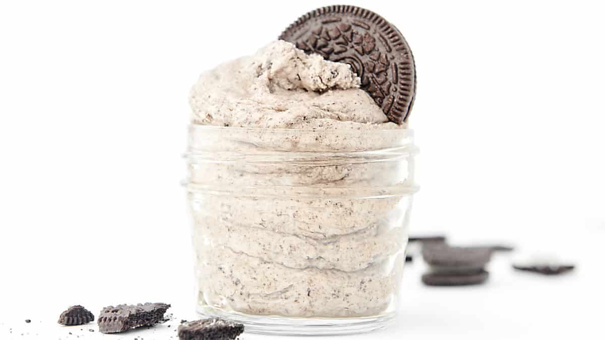 whipped oreo buttercream frosting in a glass jar topped with an oreo cookie