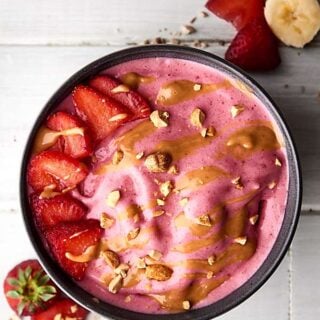 A favorite sandwich from your childhood turned into a healthy smoothie bowl: these peanut butter and jelly smoothie bowls are absolutely delicious! Full of frozen strawberries and all natural peanut butter, they really do taste like the childhood classic! showmetheyummy.com #smoothiebowl #smoothie