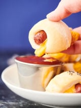 Pig in a blanket being dipped in ketchup