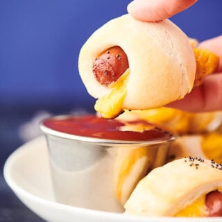 Pig in a blanket being dipped in ketchup