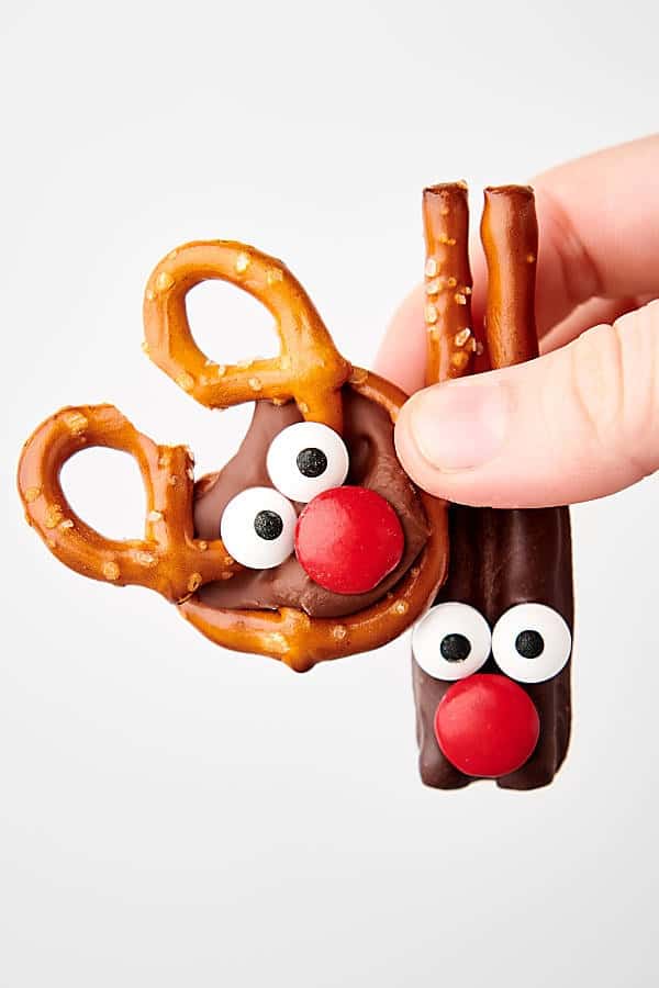 holding two reindeer pretzels in hand