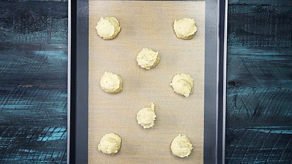 sugar cookie dough scooped on baking sheet