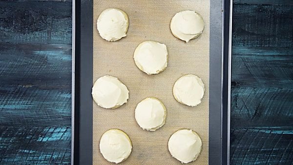 grandma's best sugar cookies frosted on baking sheet