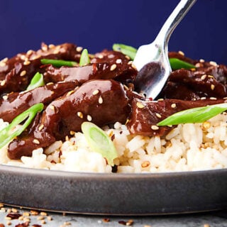 closeup of slow cooker mongolian beef on plate over rice