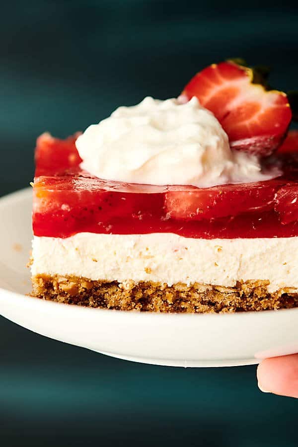 strawberry pretzel salad on plate with whipped cream