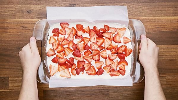 cream cheese mixture and strawberries layered in baking dish