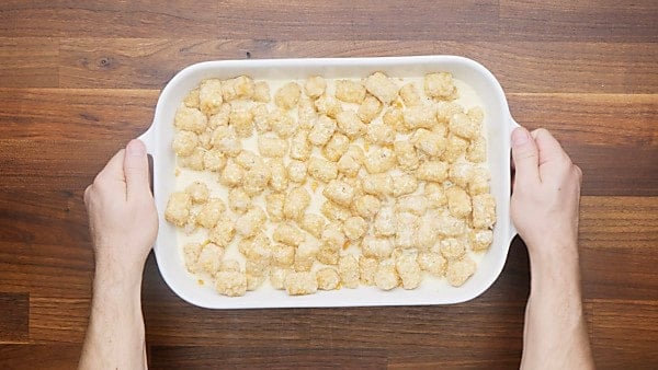 uncooked, assembled tater tot casserole in baking dish