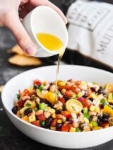 Texas caviar in a bowl with dressing being drizzled over it