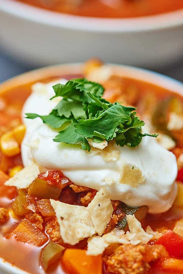 closeup of turkey and vegetable chili with sour cream and garnishes
