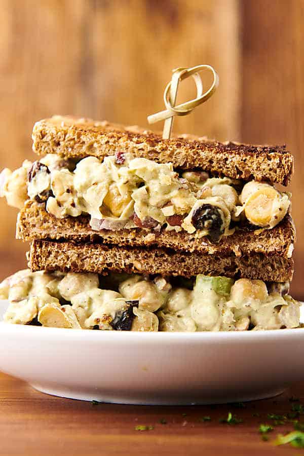 two vegan chickpea salad sandwiches stacked on a plate